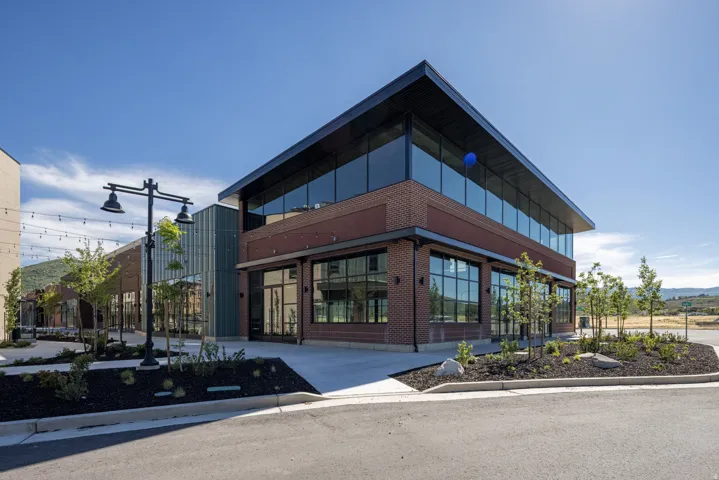 Modern architectural design featuring a striking mixed-material exterior with charred wood and brick facade, expansive multi-pane window systems, and clean geometric lines