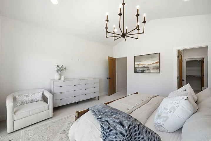 Vaulted ceiling with an iron chandelier, recessed lighting, and wood-finish doors