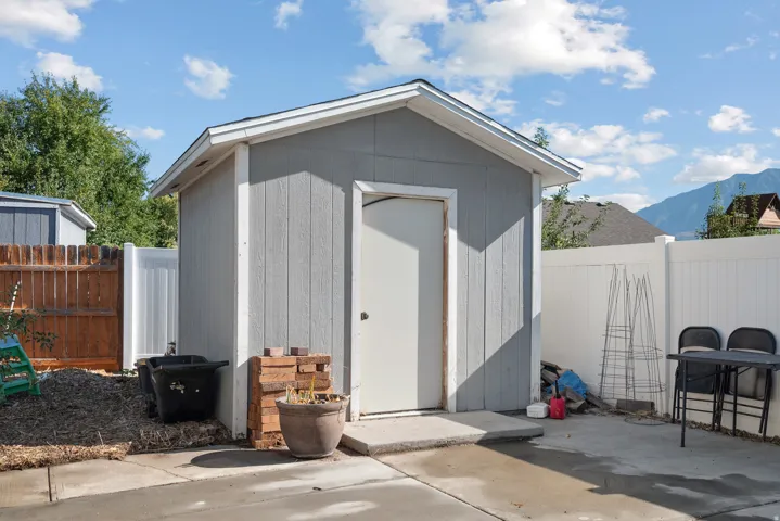 Detached storage shed with siding exterior, single entry door, and concrete pad