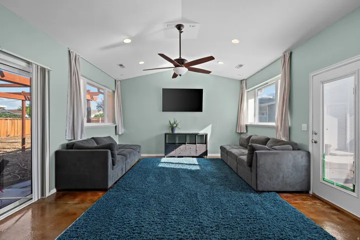 Vaulted ceiling featuring a ceiling fan, recessed lighting, and a wall-mounted television