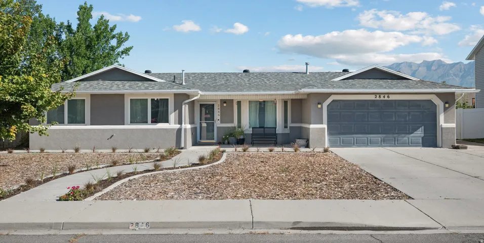 Single-story residence featuring a gray exterior, attached garage, concrete driveway, and a curved front walk