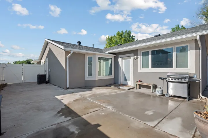 Expansive concrete patio area with a white privacy fence
