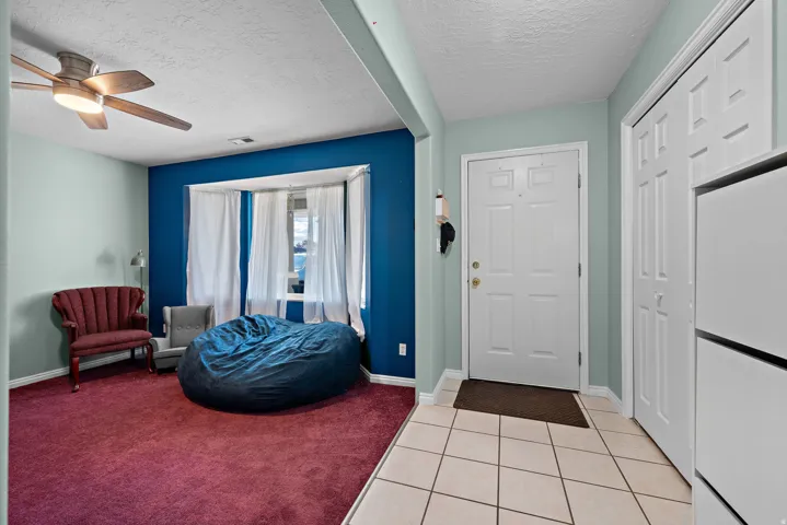 Entryway with light-colored tile flooring, white paneled entry door, and a built-in closet with bi-fold doors