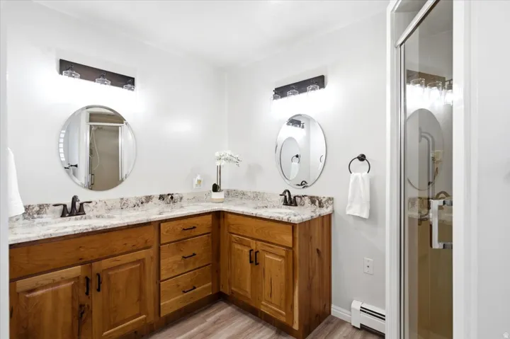 The fully updated primary bathroom features a large walk-in shower with a cultured marble surround.