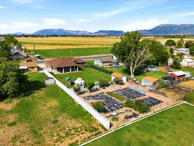 The expansive backyard includes a large garden area, gazebo, storage shed, automatic sprinklers, and secondary water, all framed by beautiful mountain views.