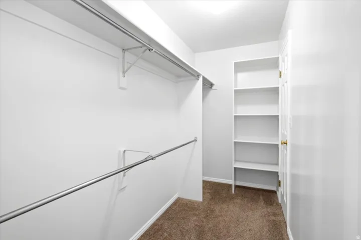 The primary suite’s walk-in closet features space-saving shelving for organized storage.