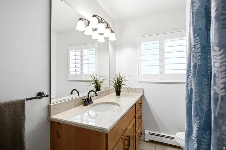 One of the home’s updated bathrooms features a spacious vanity and plantation shutters.