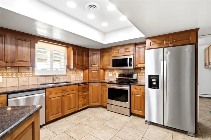 Remodeled approximately seven years ago, the kitchen features granite countertops, soft-close cherry cabinetry, roll-out drawers, and stainless steel appliances.
