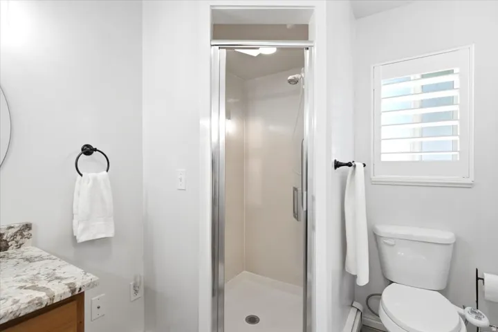 A closer look at the primary bathroom’s large walk-in shower with a cultured marble surround.