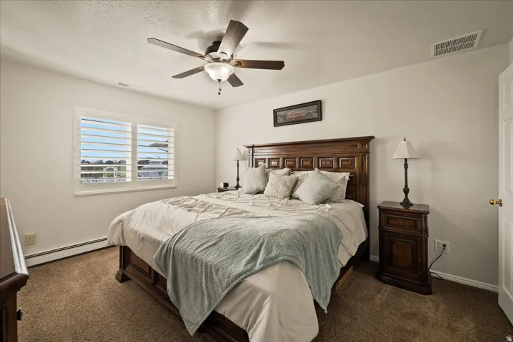 The spacious main level primary suite features plantation shutters and an updated private bathroom with a walk-in closet.