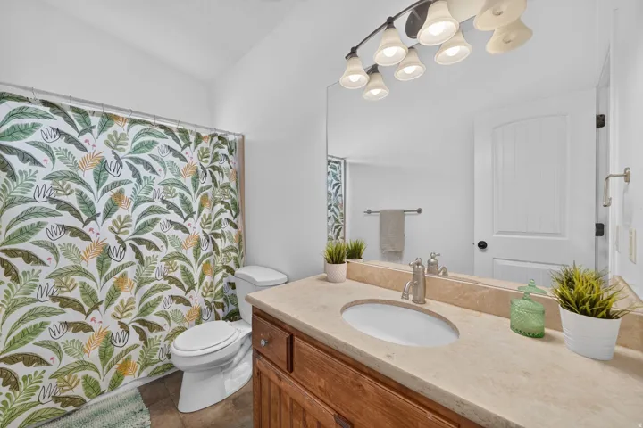 Integrated vanity with an undermount sink, a warm wood-finish cabinet, and a neutral countertop