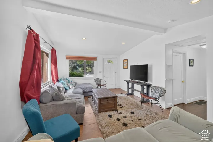 Vaulted ceilings, recessed lighting, and a white paneled entry door