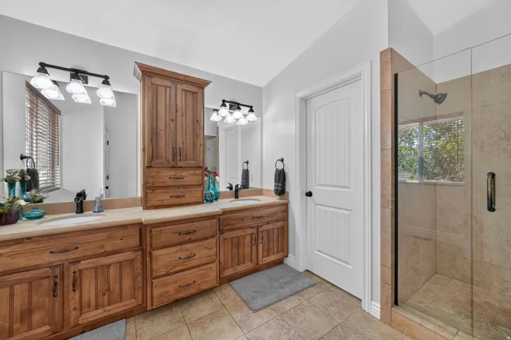 Dual vanity with wood cabinetry and light-toned countertops