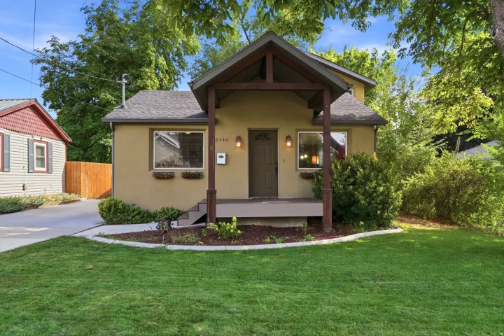 Stucco exterior with a covered porch featuring wood posts and a pitched roof