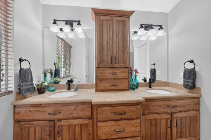 Dual vanities with integrated sinks, wood-finish cabinetry, and countertop