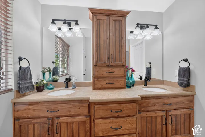 Dual vanities with integrated sinks, wood-finish cabinetry, and countertop