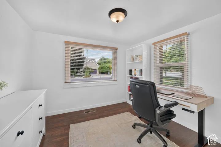 White painted walls, wood-finish flooring, and recessed lighting
