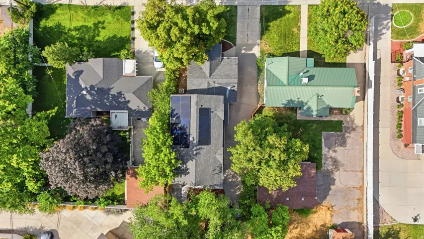 Aerial perspective showcasing residential properties with mature trees, paved driveways, and green lawns