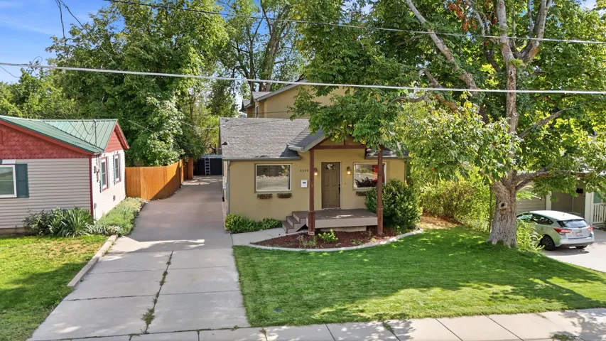 Front exterior featuring a covered porch, landscaped front yard, and a paved driveway
