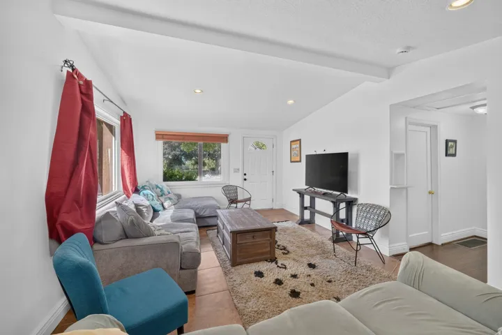 Vaulted ceilings, recessed lighting, and a white paneled entry door