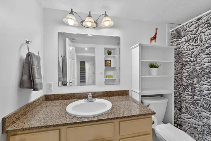 Bathroom vanity featuring a speckled countertop and an undermount sink