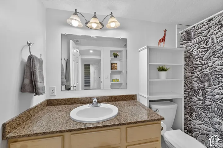 Bathroom vanity featuring a speckled countertop and an undermount sink