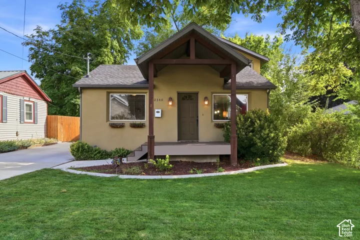 Stucco exterior with a covered porch featuring wood posts and a pitched roof