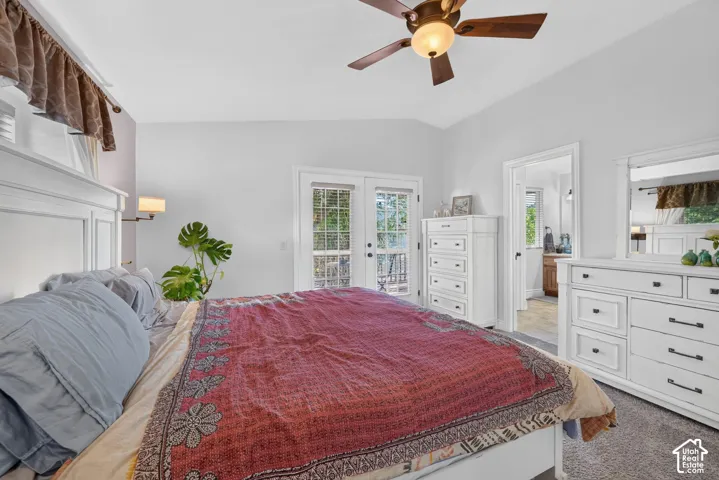 Vaulted ceiling with a ceiling fan, French doors leading to exterior, and an additional doorway to another room