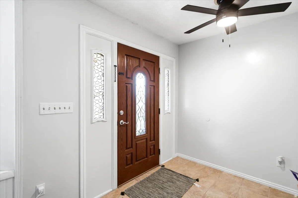Welcoming foyer featuring a solid wood entry door with decorative glass panels, sidelights, and transom window detail