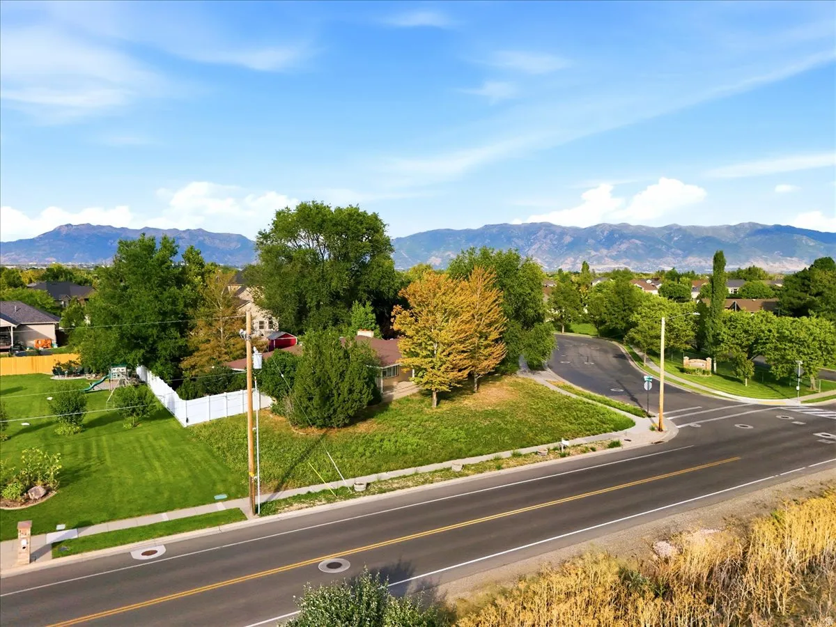 Scenic corner lot with mature landscaping, manicured lawn, and established trees