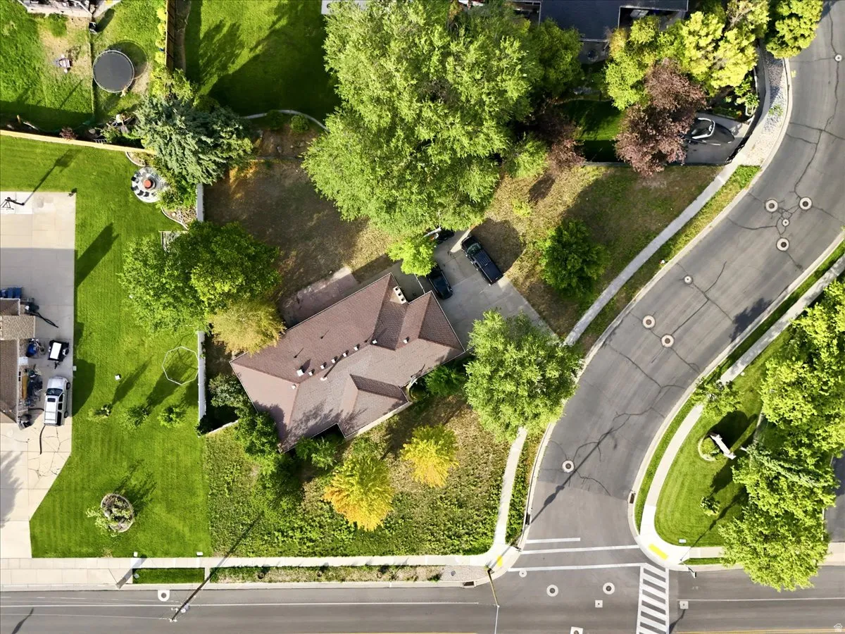 Aerial view showcasing a distinctive architectural residence nestled within mature landscaping and established trees