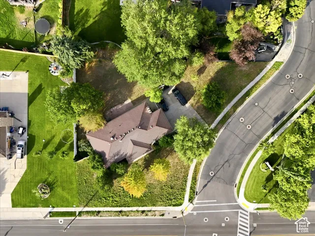 Aerial view showcasing a distinctive architectural residence nestled within mature landscaping and established trees