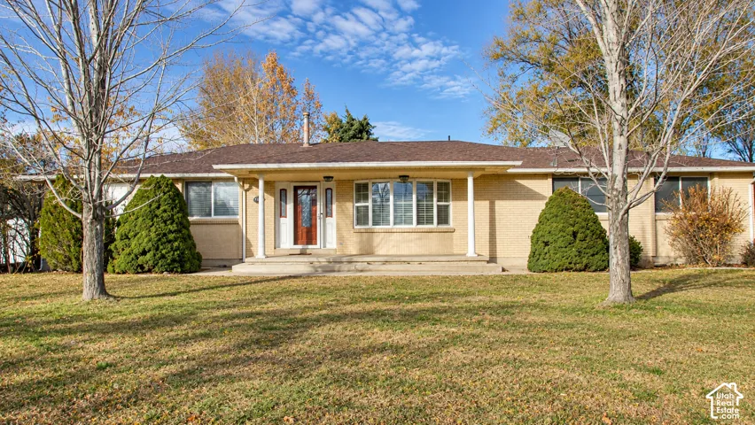 Ranch-style exterior with a covered entry, decorative columns, and a prominent front door with sidelights