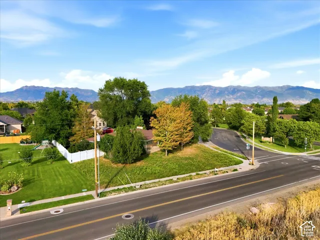 Scenic corner lot with mature landscaping, manicured lawn, and established trees