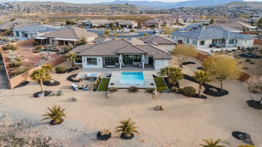 Modern exterior with a tiled roof, multiple large windows, an in-ground swimming pool, and an outdoor spa