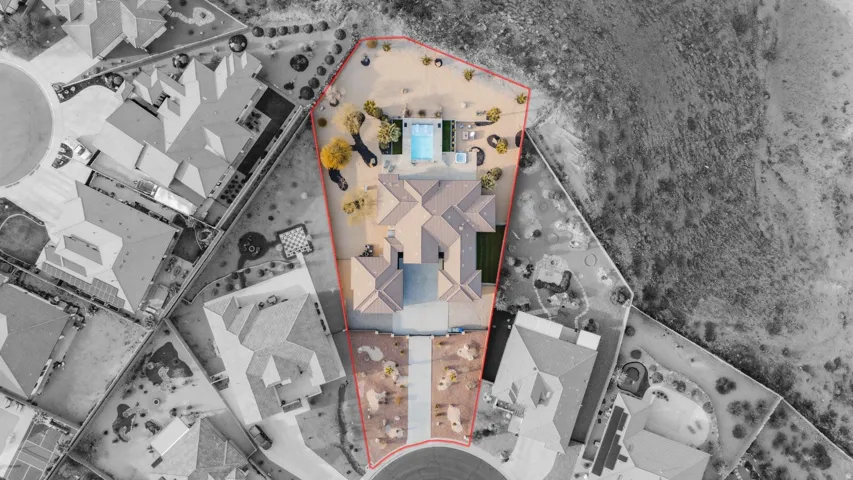 Expansive desert landscaping featuring a swimming pool, integrated spa, and an extended paver driveway