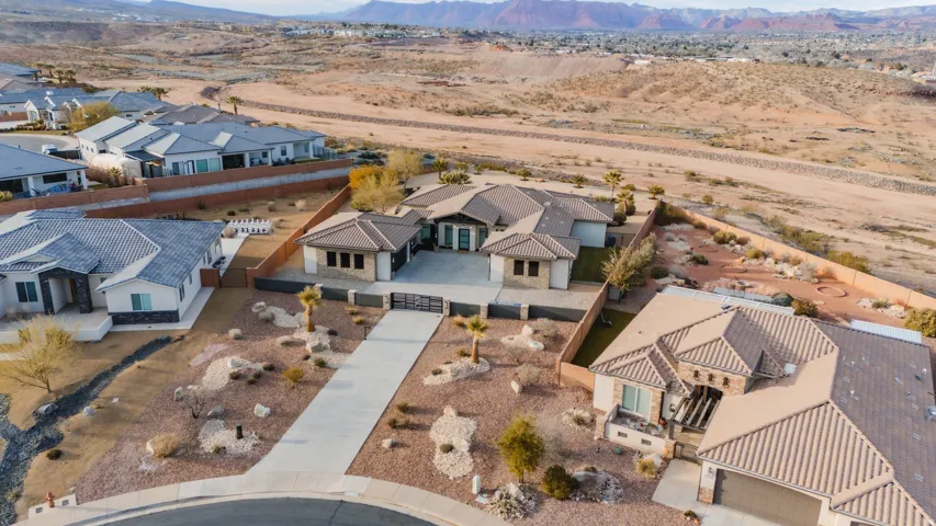 Extensive desert landscaping, paved driveway, and perimeter fencing