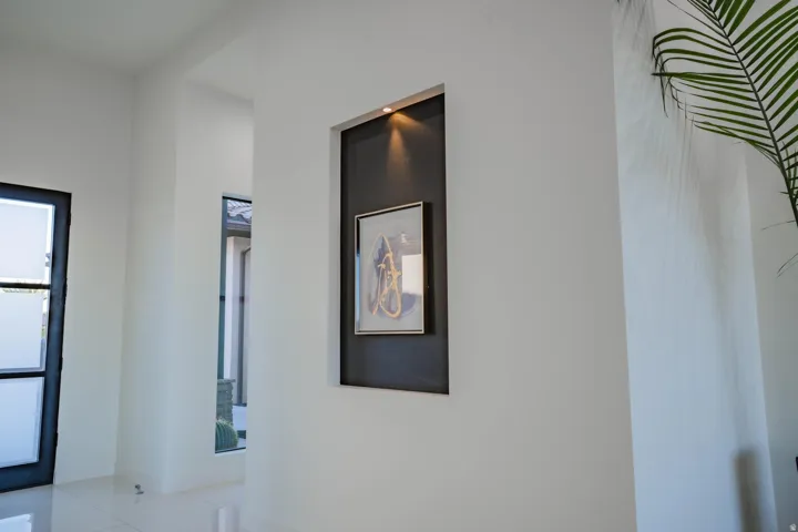 Recessed wall niche with integrated lighting, framed opening, and tiled flooring