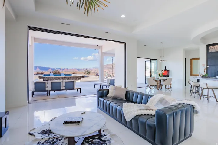 Expansive sliding glass doors, polished flooring, recessed lighting, tray ceiling, and a built-in outdoor bar