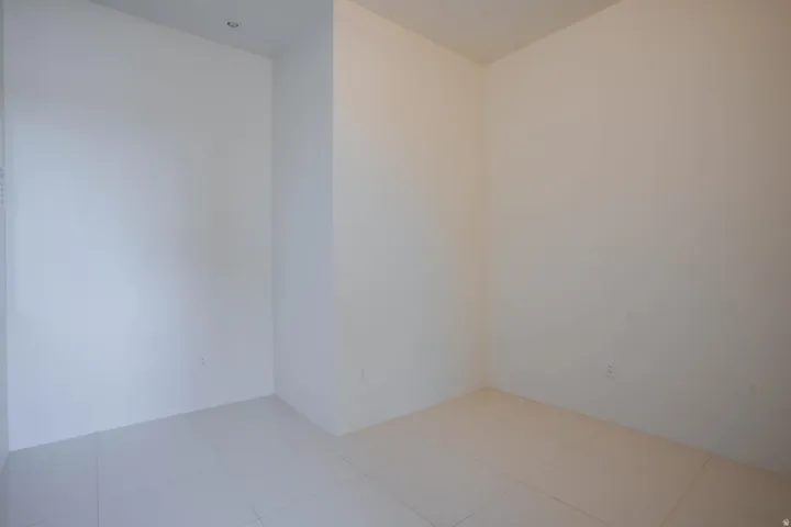 Recessed ceiling lighting, light-toned tile flooring, and neutral wall tones