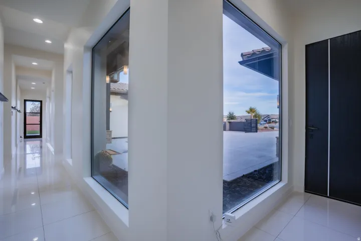 Hallway featuring large format tile flooring, recessed lighting, and a modern entryway door