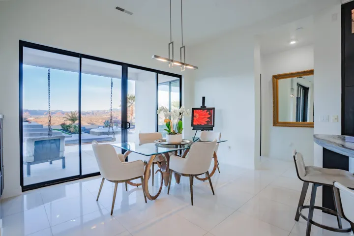 Sliding glass doors, white tile flooring, recessed lighting, and a contemporary linear chandelier
