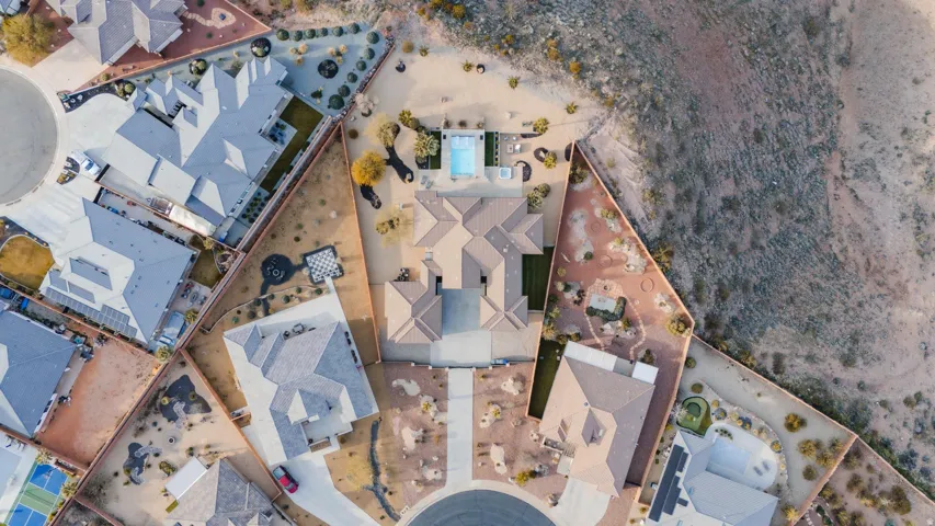 Expansive property featuring a central residence, a rectangular swimming pool, and extensive desert landscaping
