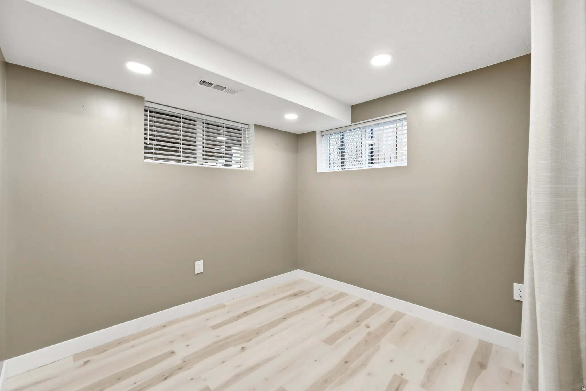 Recessed lighting, light-toned walls, wood-finish flooring, and white trim