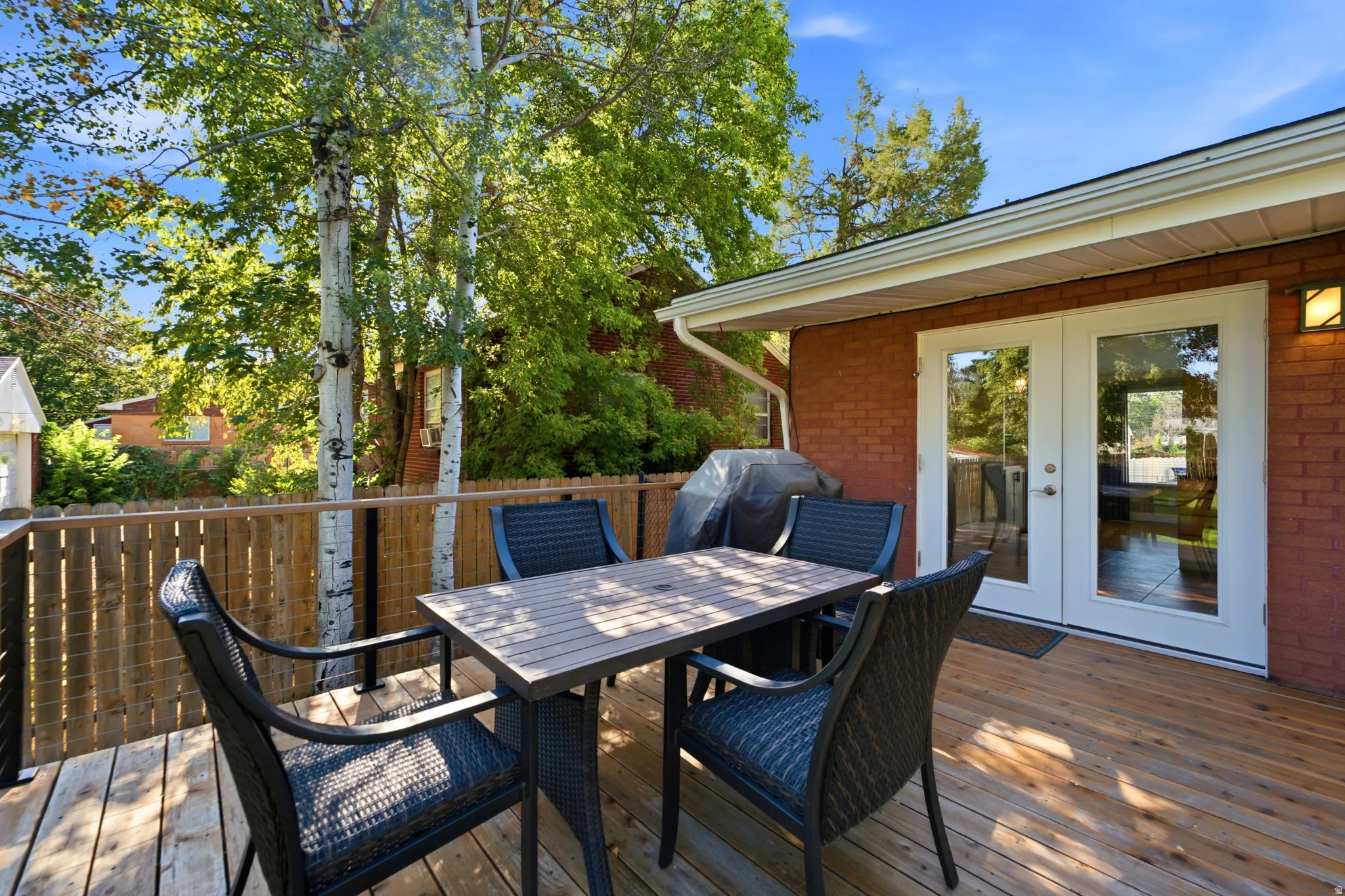 Expansive wood-finish deck with a wood privacy fence and mature trees
