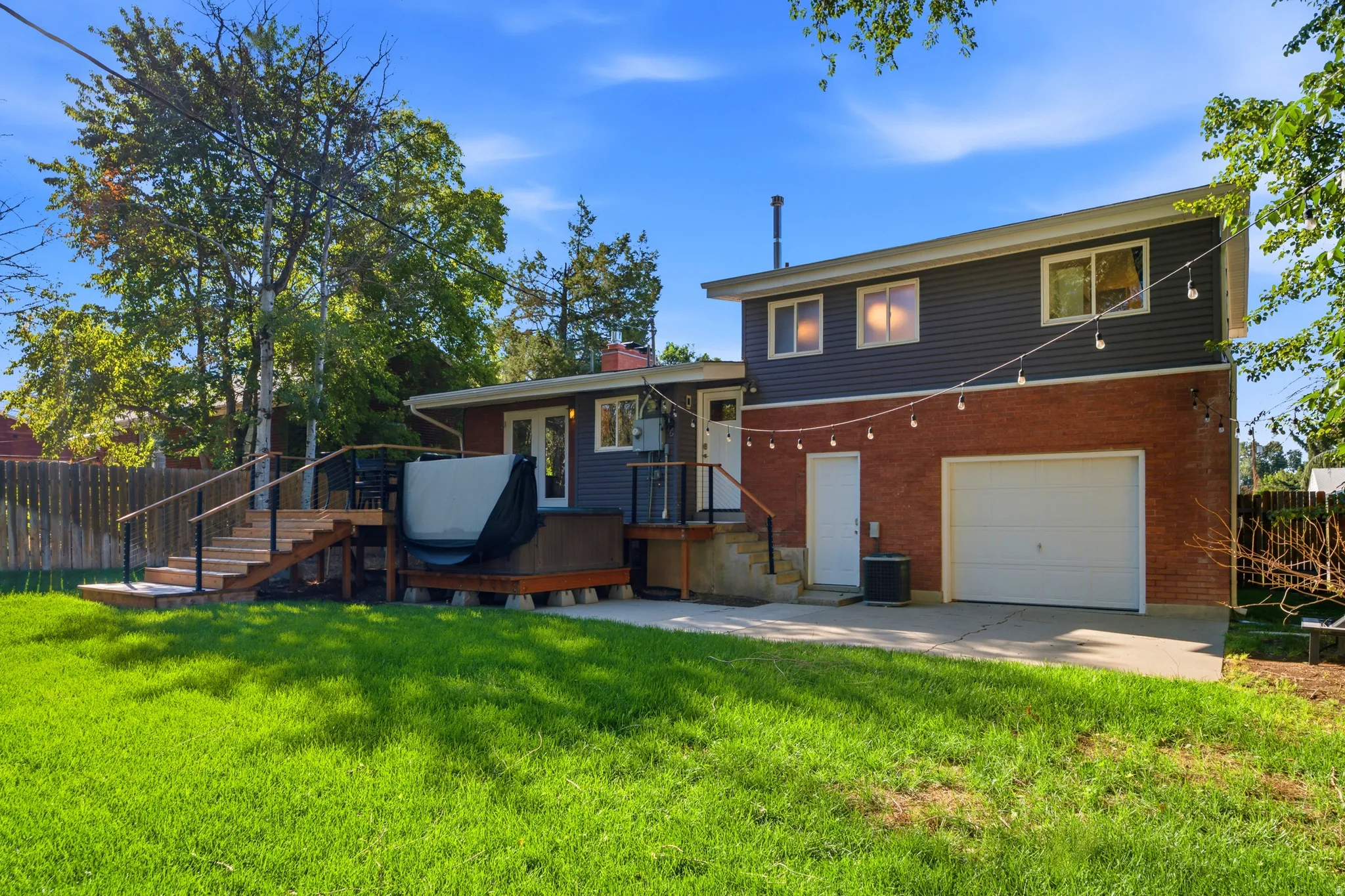 Expansive backyard featuring a manicured lawn, multi-level wood deck, and wood fence