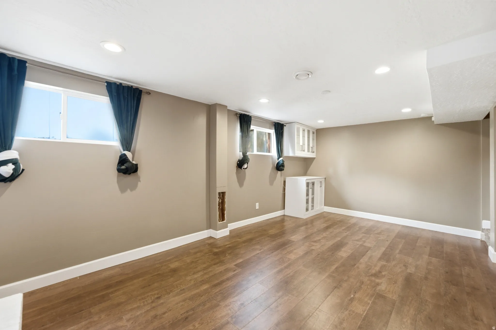 Recessed lighting, wood-finish flooring, and white trim