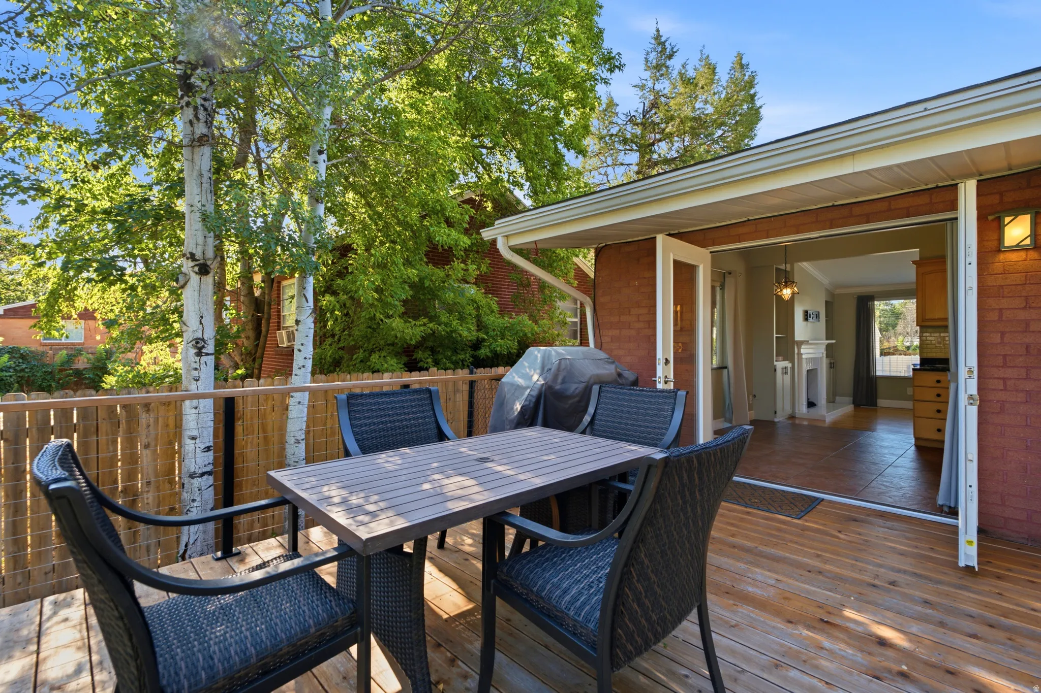 Expansive wood-finish deck with French doors leading to interior