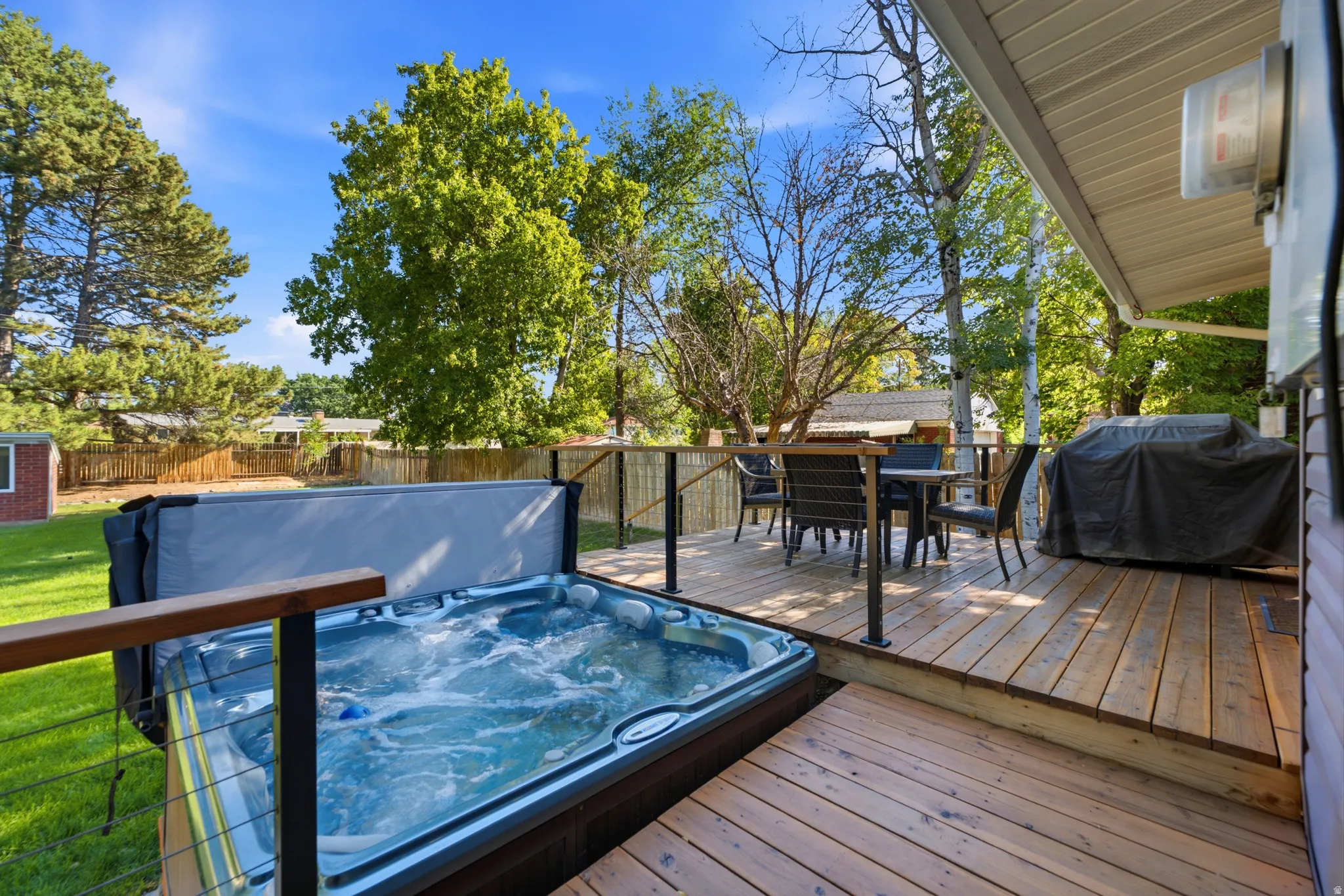 Wood deck featuring a hot tub and cable railing