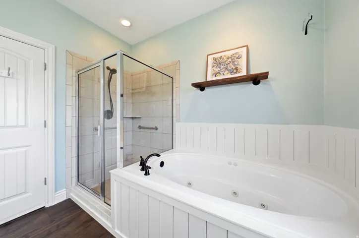 Primary bathroom with dual sinks, walk in shower, and jetted tub